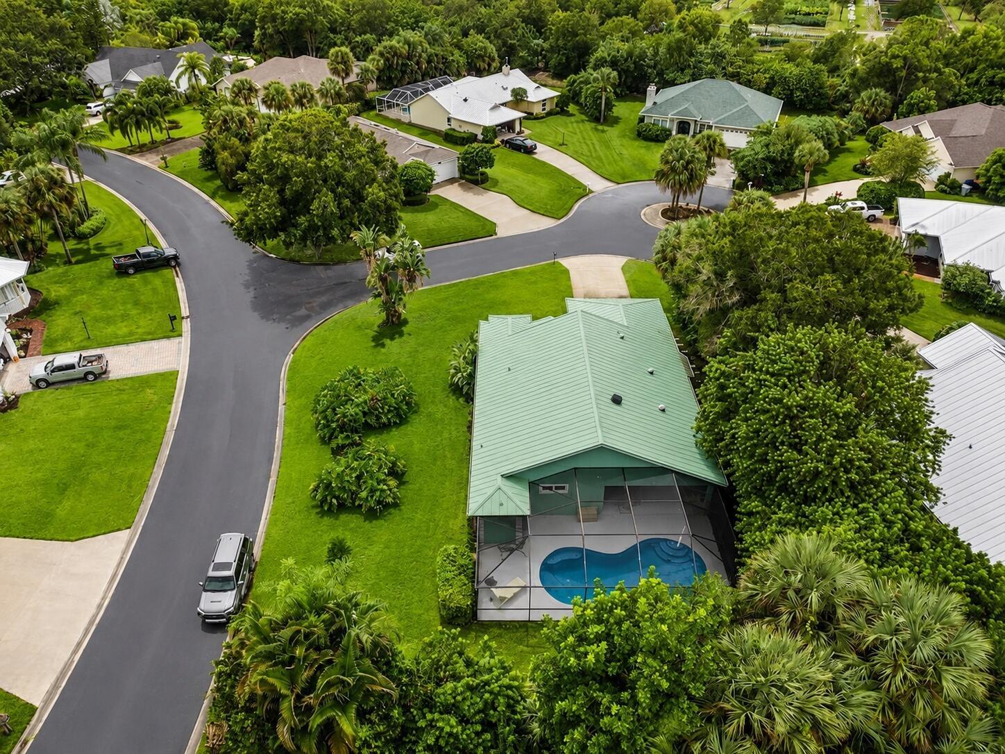 An aerial view of a suburban neighborhood featuring a house with a green metal roof — 5850 39th Ln Lane, Vero Beach FL 32966, VERO BEACH, FL
