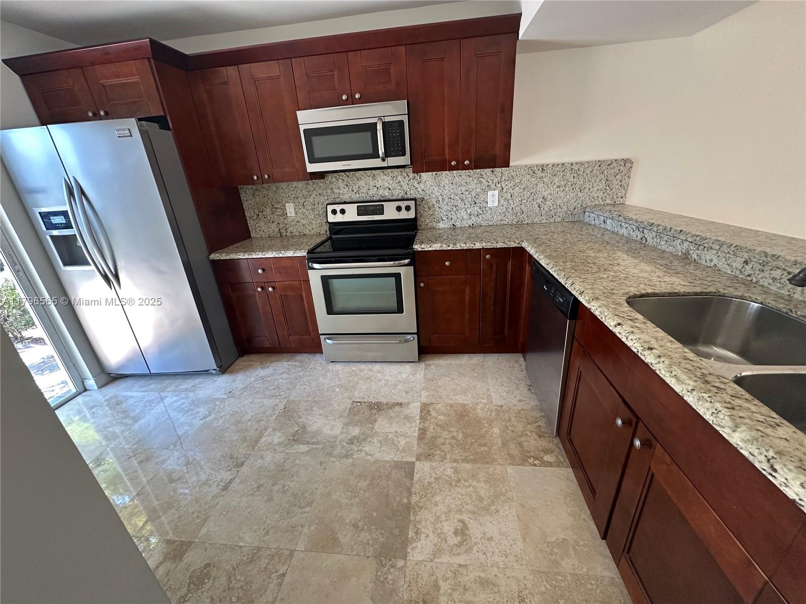 A kitchen features dark wood cabinets, granite countertops, stainless steel appliances, and light tile flooring — 878 Crystal Lake Dr, Deerfield Beach FL 33064, DEERFIELD BEACH, FL