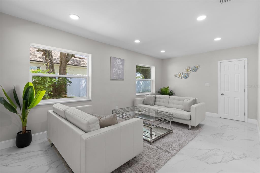 A living room features white sofas, a glass coffee table, and tile flooring — 1375 LAKE DRIVE, CASSELBERRY, FL