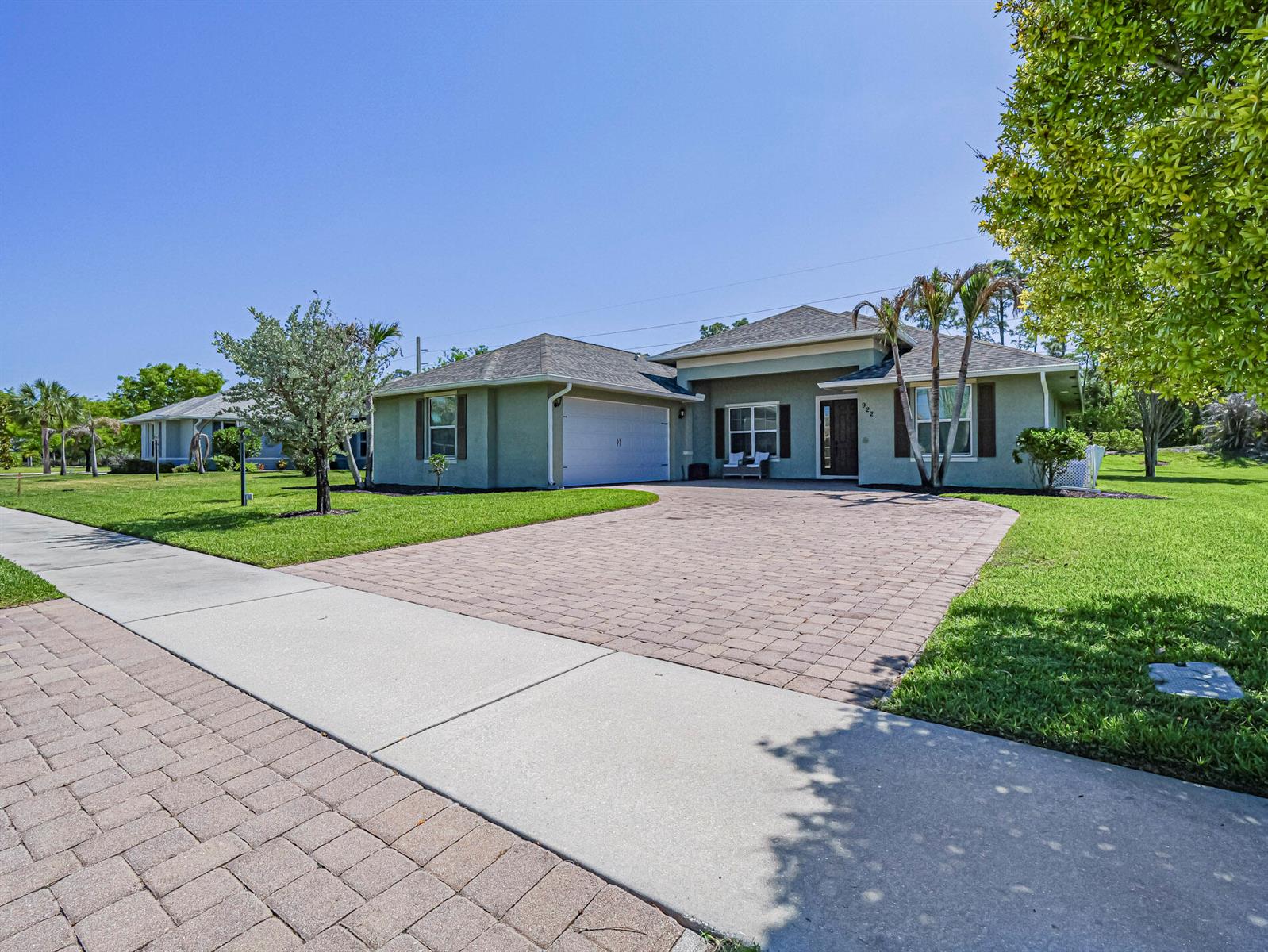A single-story house with a paved driveway, green stucco exterior, and a two-car garage — 922 Yearling Trail, Sebastian FL 32958, SEBASTIAN, FL
