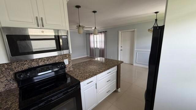 A kitchen features white cabinets, granite countertops, stainless steel appliances, and a breakfast bar — 276 Monaco F, Delray Beach FL 33446, DELRAY BEACH, FL