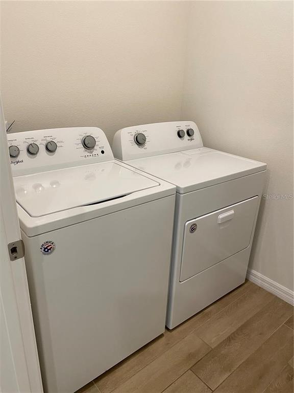 A laundry room features a white top-loading washing machine and a matching dryer — 8244 SW 60TH ROAD, GAINESVILLE, FL