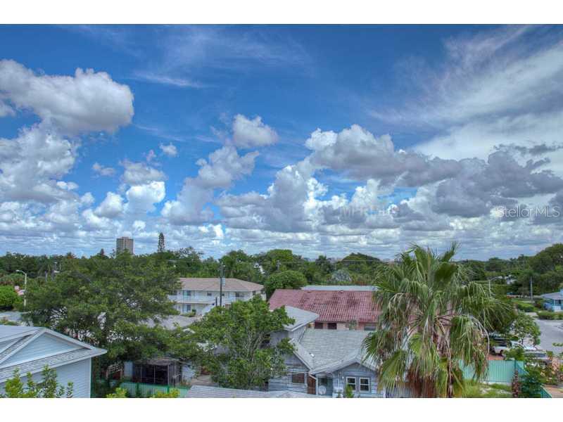 An elevated view of a residential neighborhood with houses, trees, and a cloudy blue sky — 131 GARFIELD DRIVE UNIT 4C, SARASOTA, FL