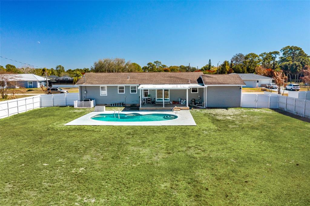 A single-story house with a backyard swimming pool and a white vinyl fence — 323 GREENWOOD AVENUE, LEHIGH ACRES, FL