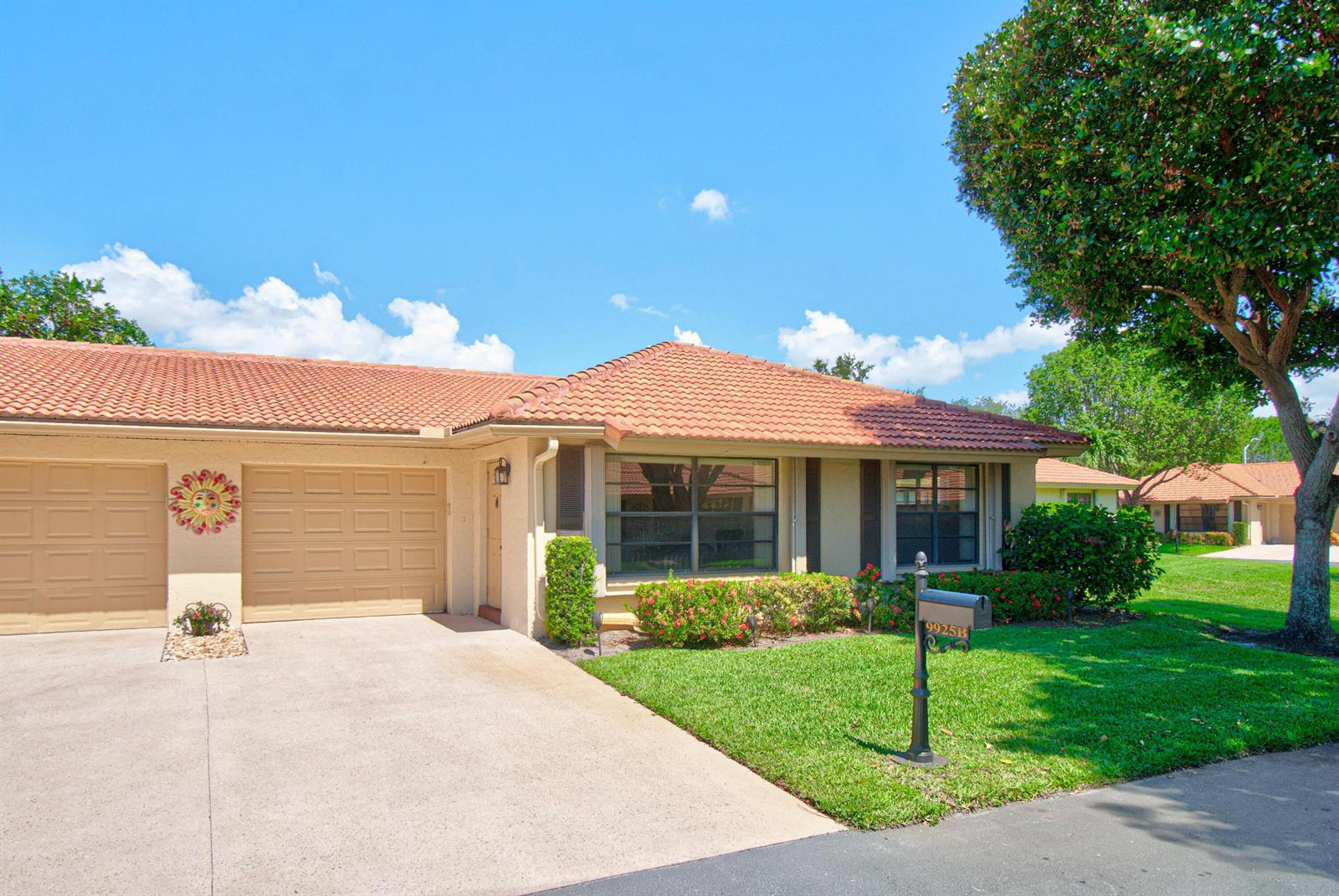 A single-story house with a tan stucco exterior, tile roof, and a two-car garage — 9925 Frangipani Tree Way # B, Boynton Beach FL 33436, BOYNTON BEACH, FL