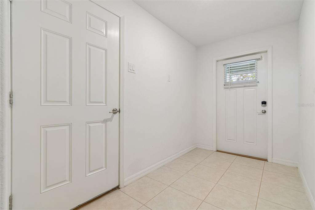 A small room with white walls, tiled flooring, and two white doors — 4436 TUSCAN LOON DRIVE, TAMPA, FL