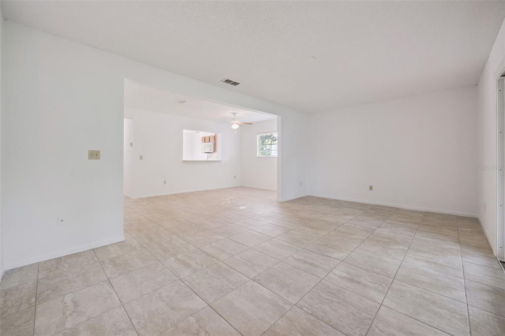 An open-concept living area features white walls and light-colored tile flooring throughout — 498 GREEN SPRING CIR, WINTER SPRINGS, FL