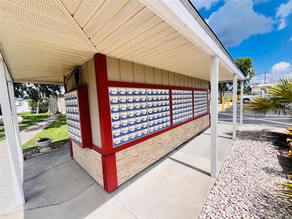 An outdoor mail kiosk with numerous individual mailboxes under a covered walkway — 2215 73RD STREET E UNIT 348, PALMETTO, FL