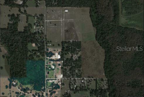 An aerial view shows a large plot of land with fields, trees, and scattered buildings — 1349 N FORT CHRISTMAS ROAD, CHRISTMAS, FL