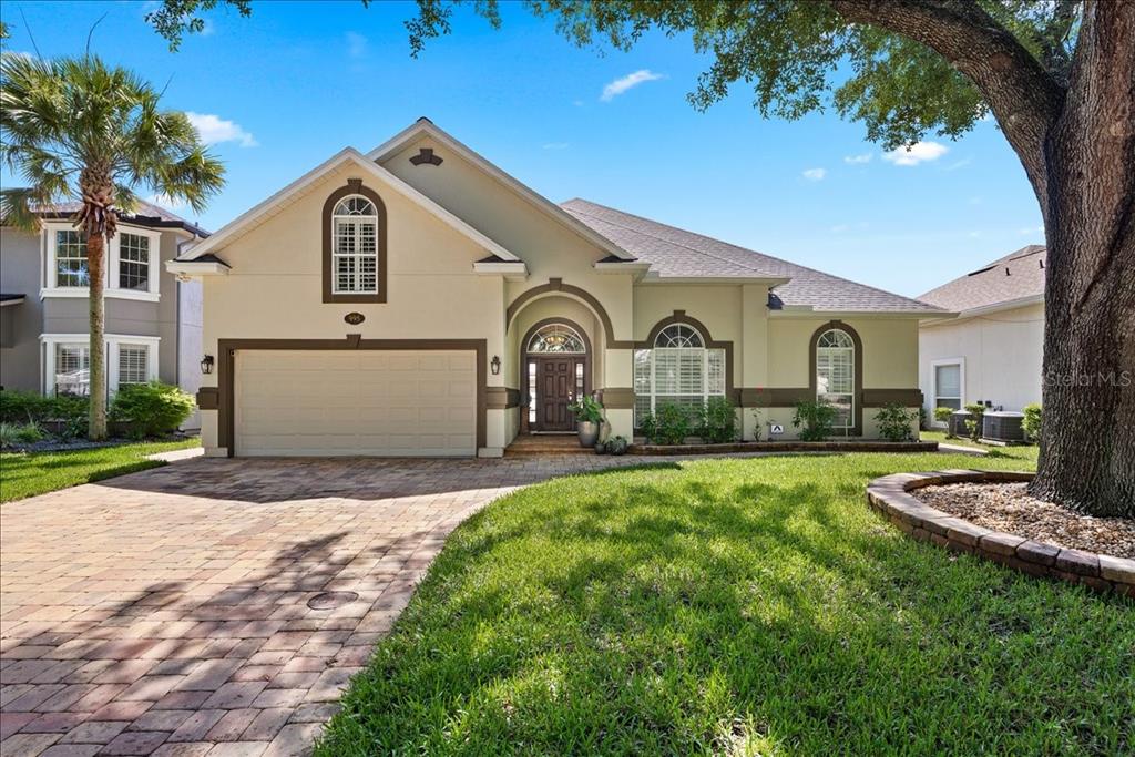 A single-story house with a beige stucco exterior, a two-car garage, and a paved driveway — 995 GARRISON DRIVE, ST AUGUSTINE, FL