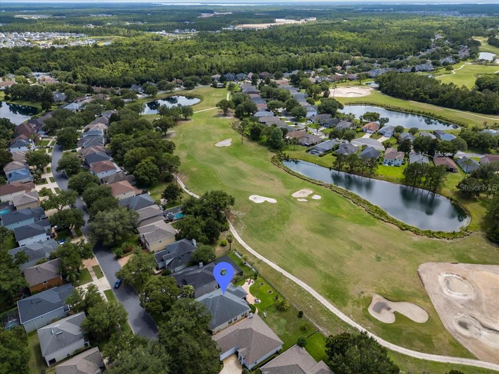 An aerial view shows a suburban house with a blue location marker near a golf course — 995 GARRISON DRIVE, ST AUGUSTINE, FL