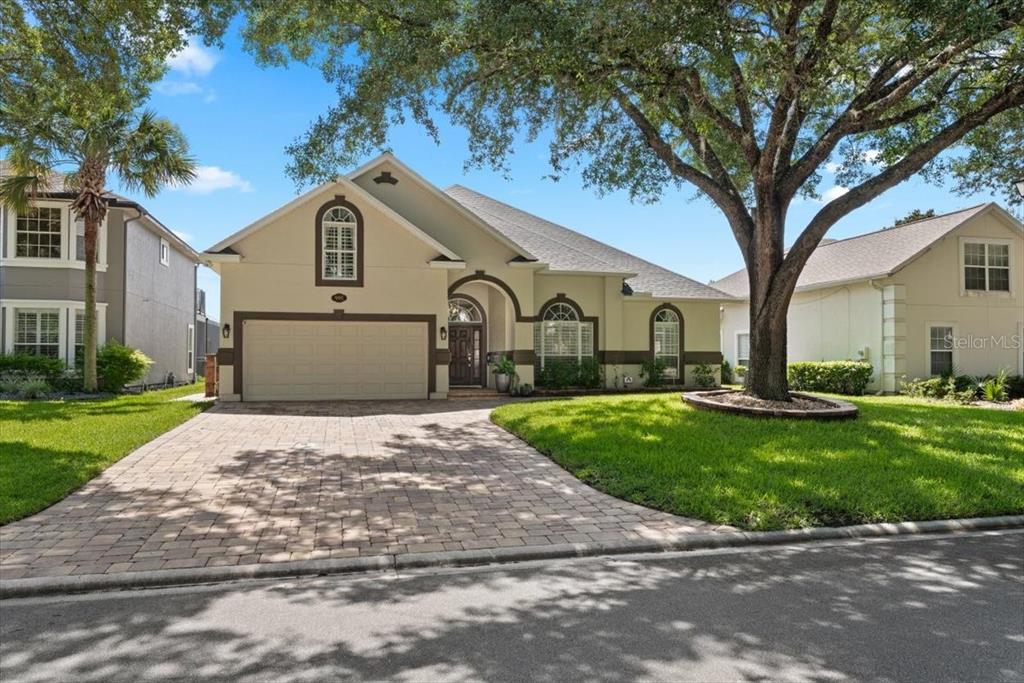 A single-story house with a paved driveway, a two-car garage, and a large front tree — 995 GARRISON DRIVE, ST AUGUSTINE, FL