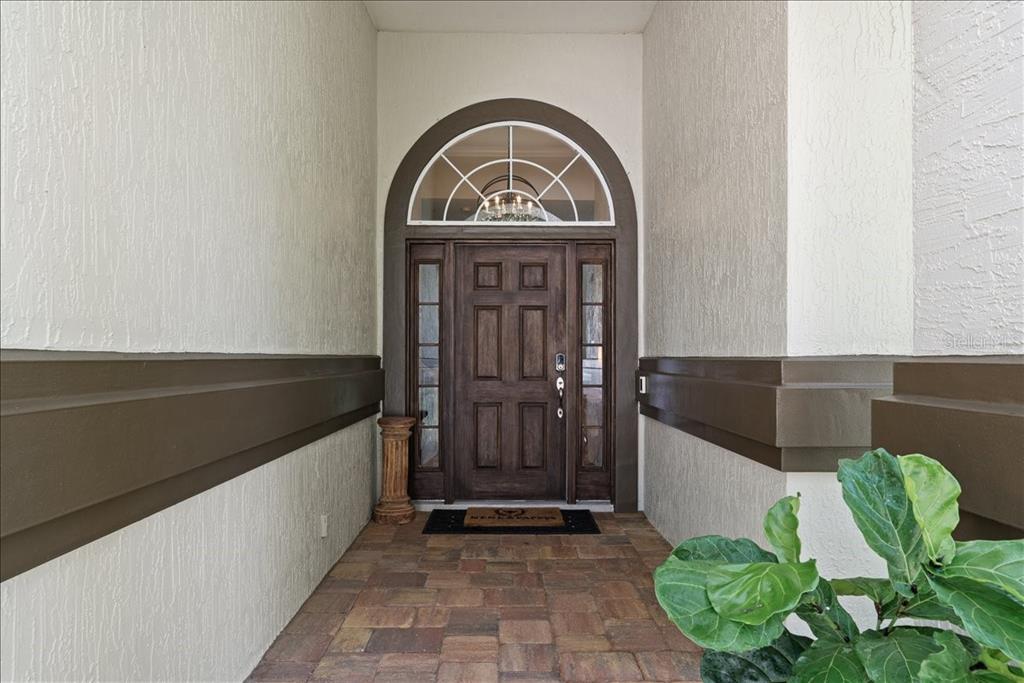 A front entryway features a dark wood door with sidelights and an arched transom window — 995 GARRISON DRIVE, ST AUGUSTINE, FL