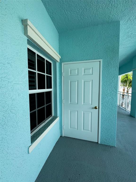 A turquoise exterior balcony features a white six-panel door and a window with muntins — 5751 SABAL TRACE DRIVE UNIT 201, NORTH PORT, FL