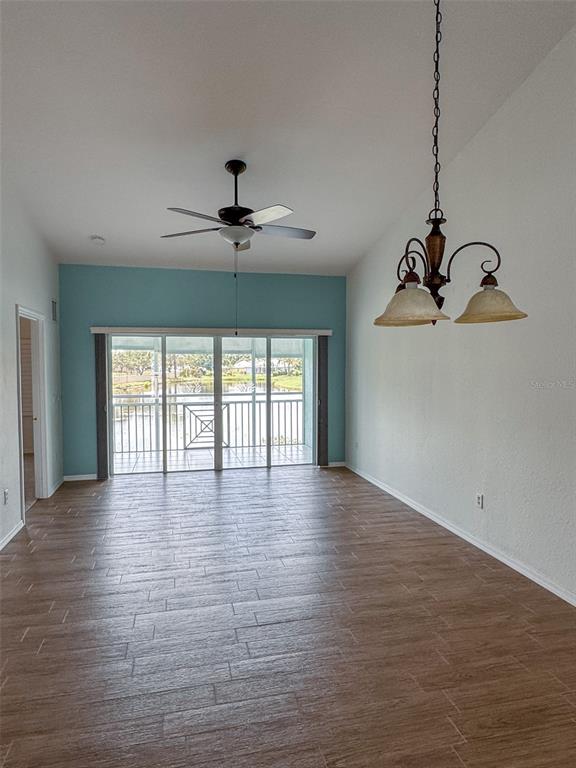 A room with wood-look tile flooring, a ceiling fan, a chandelier, and sliding glass doors — 5751 SABAL TRACE DRIVE UNIT 201, NORTH PORT, FL