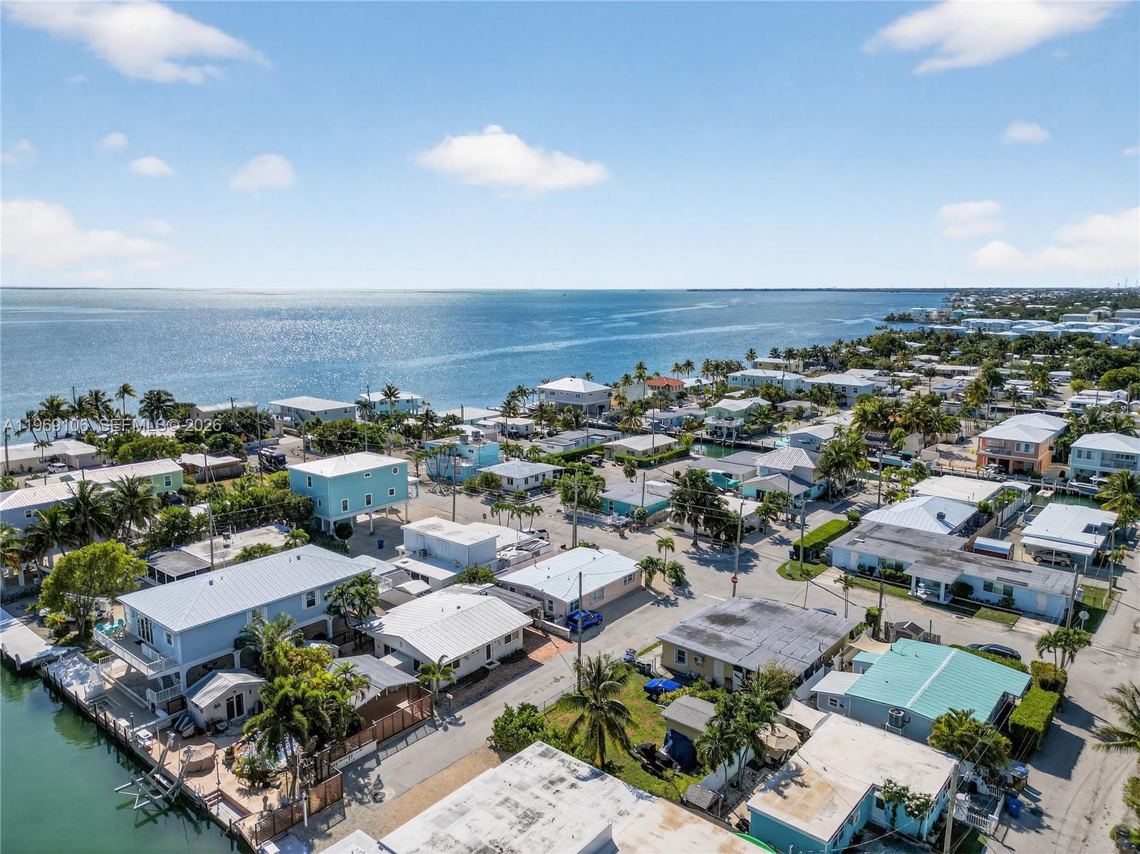 An aerial view shows a coastal neighborhood with houses, palm trees, and a canal — 11405 3rd Avenue Ocean, Marathon FL 33050, MARATHON, FL