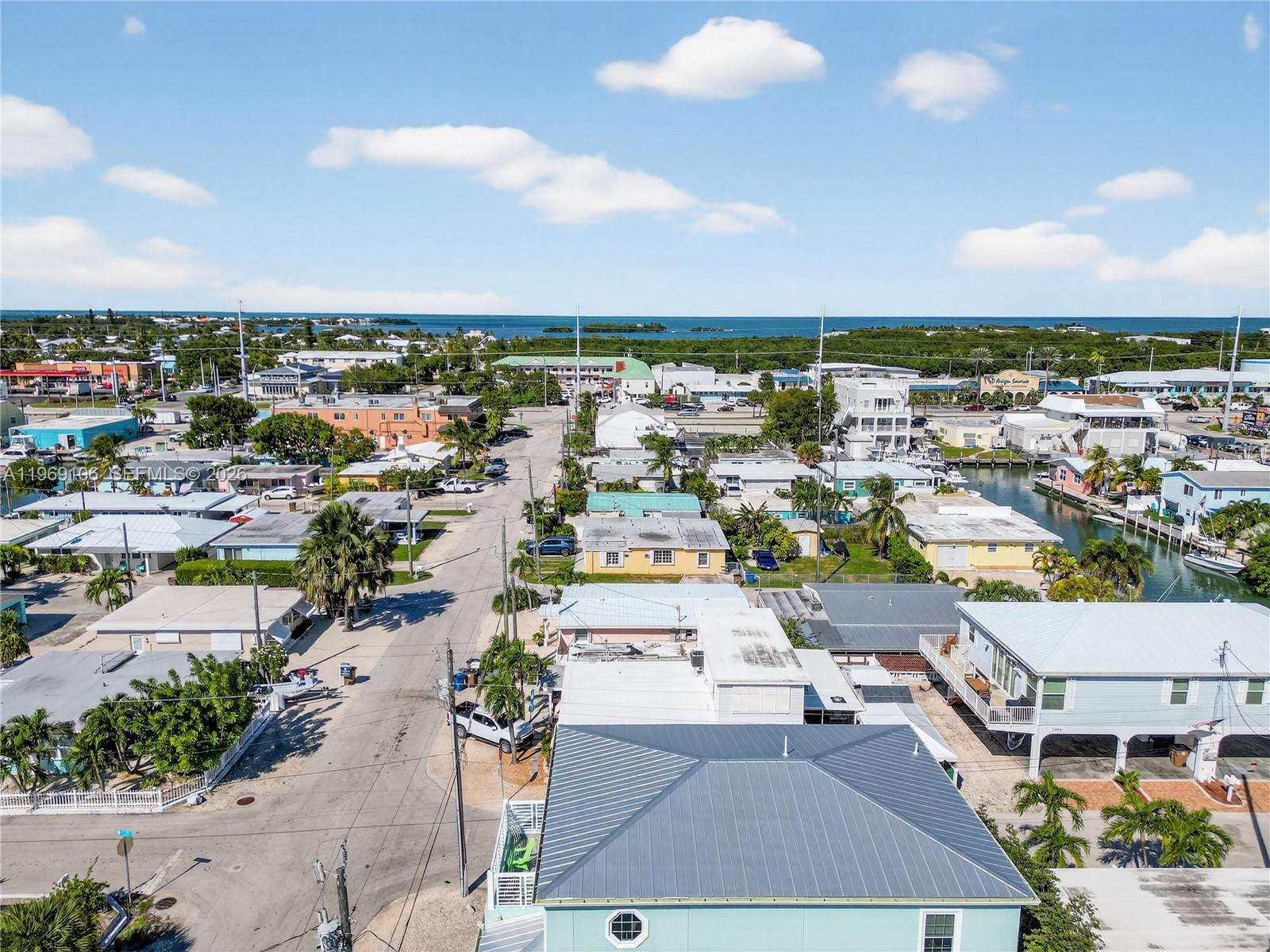 An aerial view shows a coastal neighborhood with houses, streets, and a nearby canal — 11405 3rd Avenue Ocean, Marathon FL 33050, MARATHON, FL