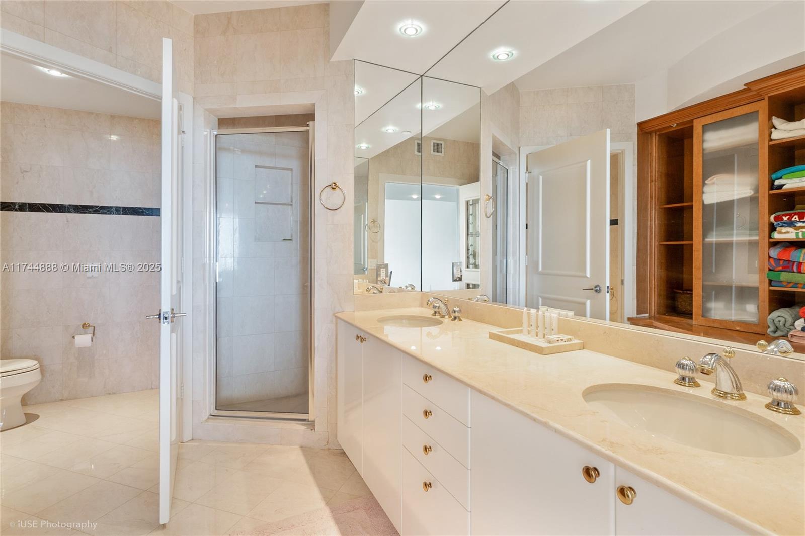 A bathroom features a double vanity with a marble countertop, a shower, and wooden shelving — 785 Crandon Blvd, Key Biscayne FL 33149, KEY BISCAYNE, FL