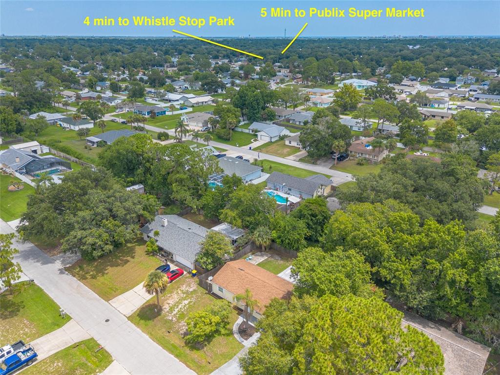 An aerial view shows a residential neighborhood with houses, trees, and labeled travel times — 3223 UMBRELLA TREE DRIVE, EDGEWATER, FL