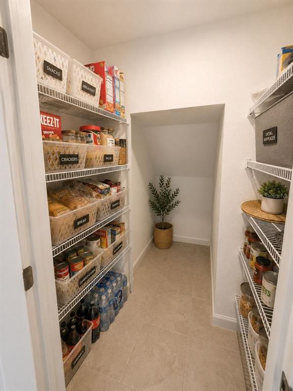 A walk-in pantry features white wire shelving, labeled storage bins, and a small potted plant — 1190 SEASIDE MIST TRAIL, KISSIMMEE, FL