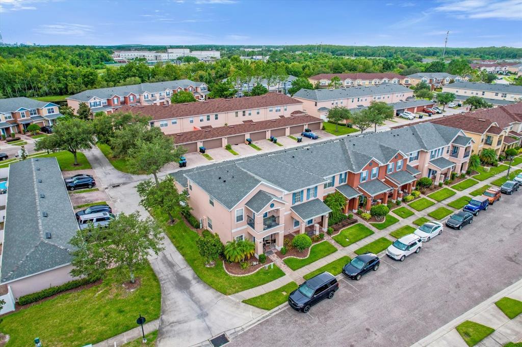 An aerial view shows a multi-unit residential complex with attached garages and street parking — 16130 OLD ASH LOOP, ORLANDO, FL