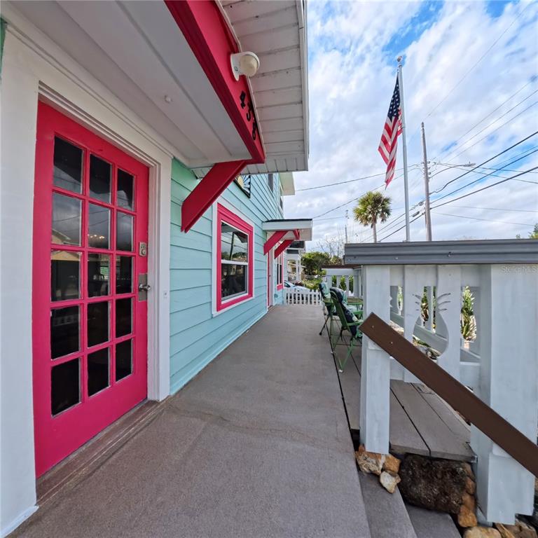 A bright pink door and light blue siding feature on the exterior porch of a house — 434 VERMONT AVENUE, DAYTONA BEACH, FL