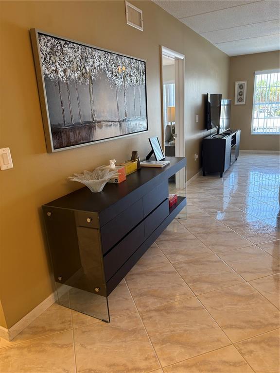 A hallway features a dark dresser with glass sides, a large landscape painting, and tile flooring — 3806 GULF OF MEXICO DRIVE UNIT C212, LONGBOAT KEY, FL