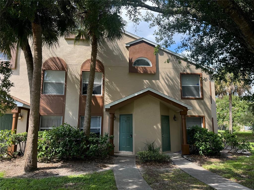 A two-story tan stucco townhouse with two green front doors and arched windows — 5436 E MICHIGAN STREET UNIT 5436-8, ORLANDO, FL