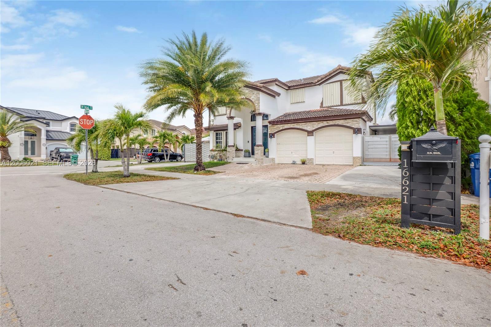 A two-story house with a two-car garage, stone accents, and palm trees in the front yard — 16621 SW 58th Ter, Miami FL 33193, MIAMI, FL