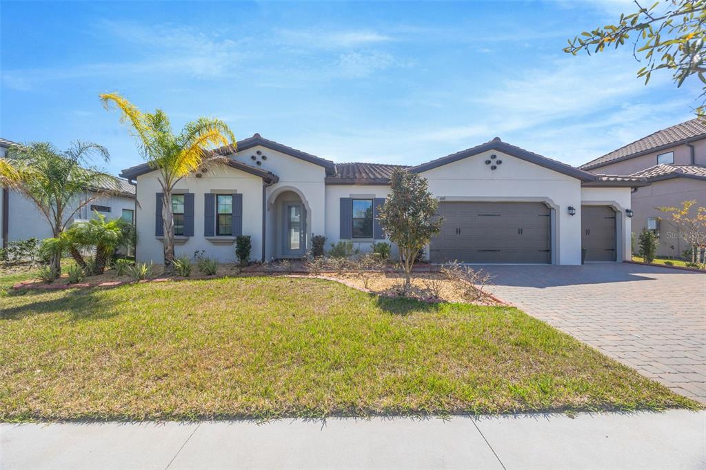 A single-story house with a stucco exterior, tile roof, and a two-car garage — 6167 MARSH TRAIL DRIVE, ODESSA, FL