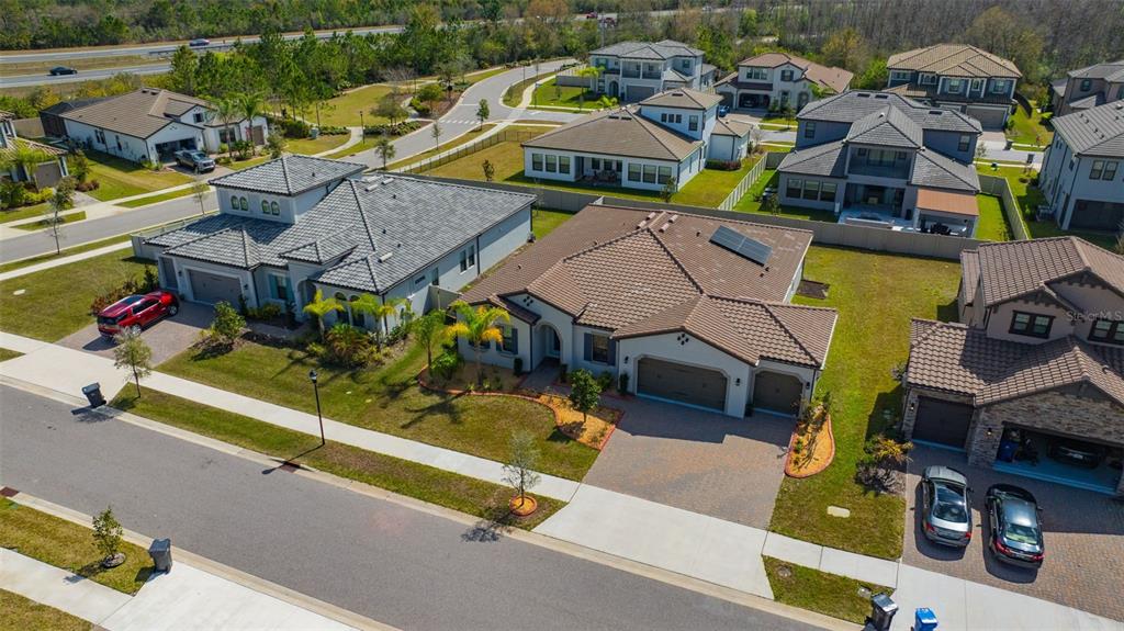 An aerial view shows several suburban houses with tiled roofs and driveways in a neighborhood — 6167 MARSH TRAIL DRIVE, ODESSA, FL