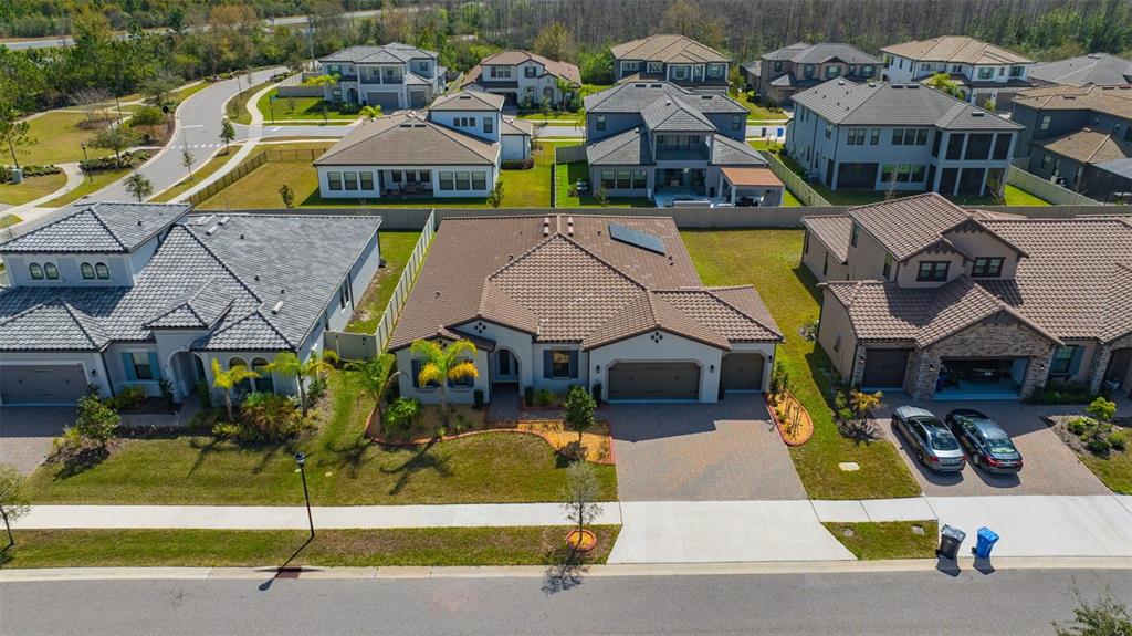 An aerial view shows a suburban neighborhood with several single-family homes and paved streets — 6167 MARSH TRAIL DRIVE, ODESSA, FL