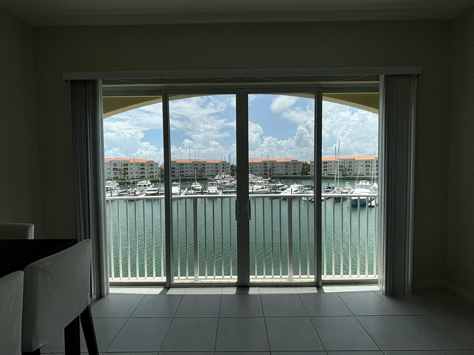 A view of a marina from a tiled room through large sliding glass doors — 10 E Harbour Isle Dr Drive E # 302, Fort Pierce FL 34949, FORT PIERCE, FL