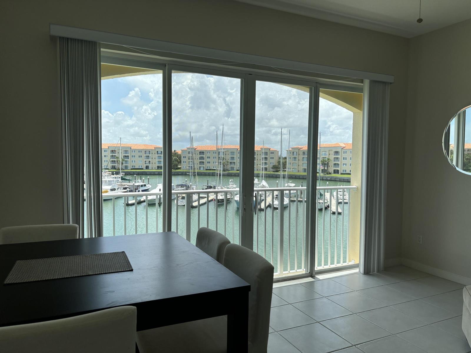 A dining area with a dark table overlooks a marina through large sliding glass doors — 10 E Harbour Isle Dr Drive E # 302, Fort Pierce FL 34949, FORT PIERCE, FL