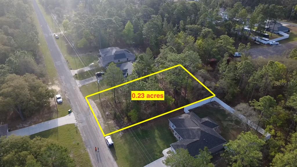 An aerial view shows a vacant, wooded residential lot outlined in yellow near a street — 2282 W WAVECREST DRIVE, DUNNELLON, FL