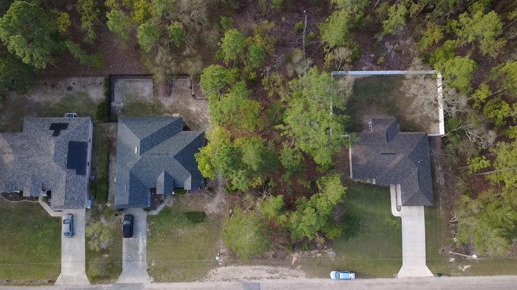 An aerial view shows two houses with driveways separated by a wooded area — 2282 W WAVECREST DRIVE, DUNNELLON, FL