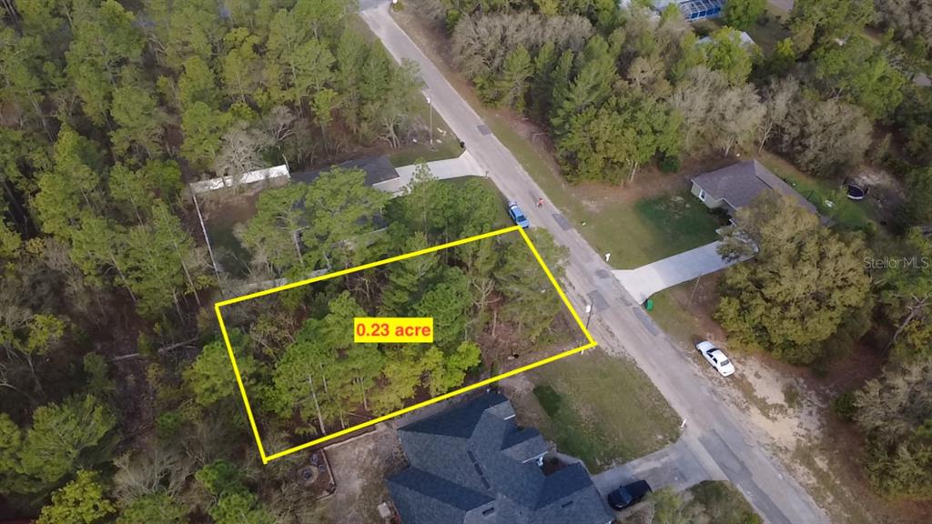 An aerial view shows a rectangular, wooded vacant lot outlined in yellow along a road — 2282 W WAVECREST DRIVE, DUNNELLON, FL
