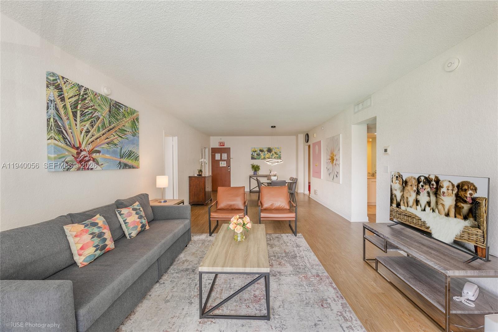 A living room features a gray sofa, two leather chairs, a coffee table, and a television — 4001 S Ocean Dr # 3B, Hollywood FL 33019, HOLLYWOOD, FL