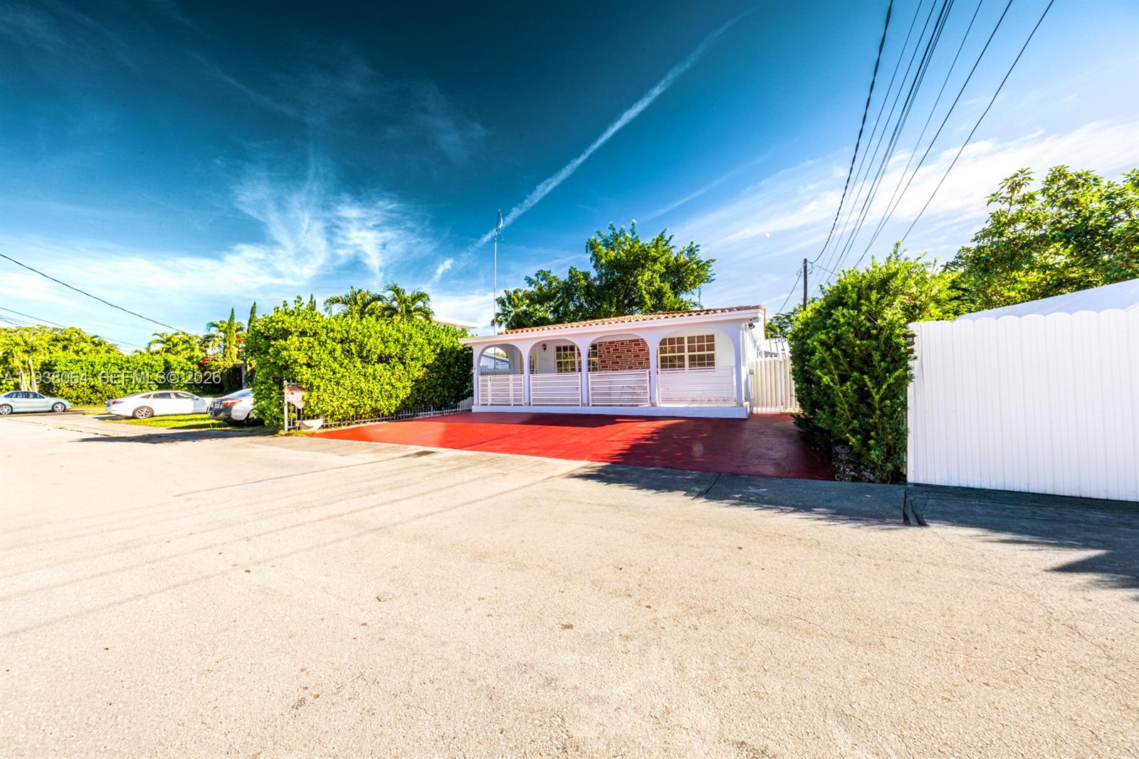 A single-story house with a red driveway and a white arched porch sits under a sky — 1937 SW 57th Ct, Miami FL 33155, MIAMI, FL