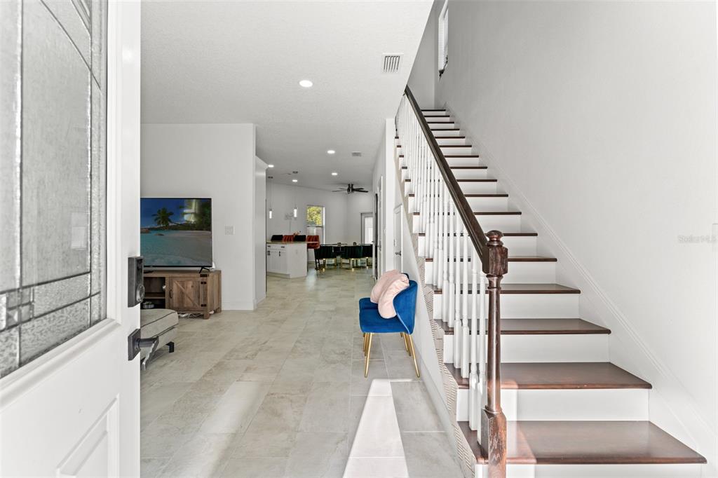 An entryway leads to a living area and kitchen with stairs on the right — 7911 N PACKWOOD AVENUE, TAMPA, FL