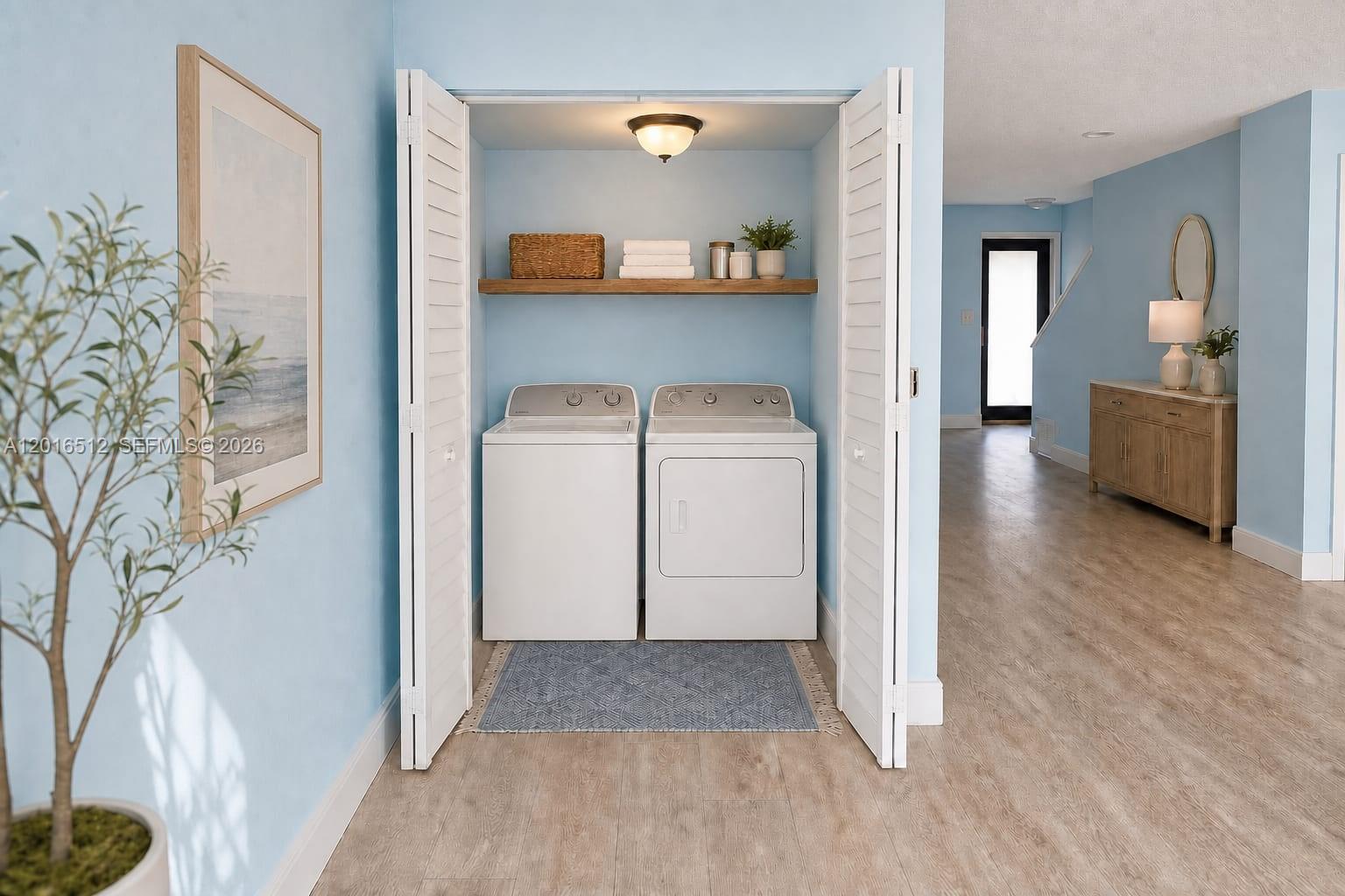 A laundry closet with white appliances and a wooden shelf sits in a blue room — 2262 NW 59th Way # 2262, Lauderhill FL 33313, LAUDERHILL, FL