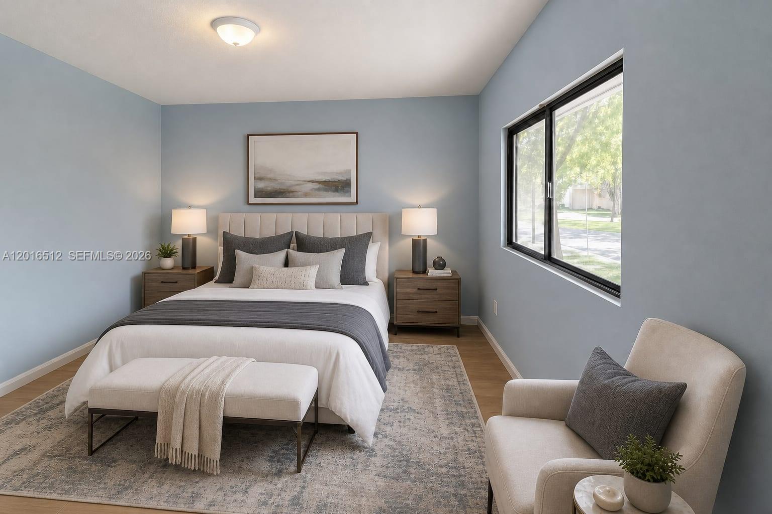 A bedroom features a bed with gray bedding, two nightstands, and an armchair by a window — 2262 NW 59th Way # 2262, Lauderhill FL 33313, LAUDERHILL, FL