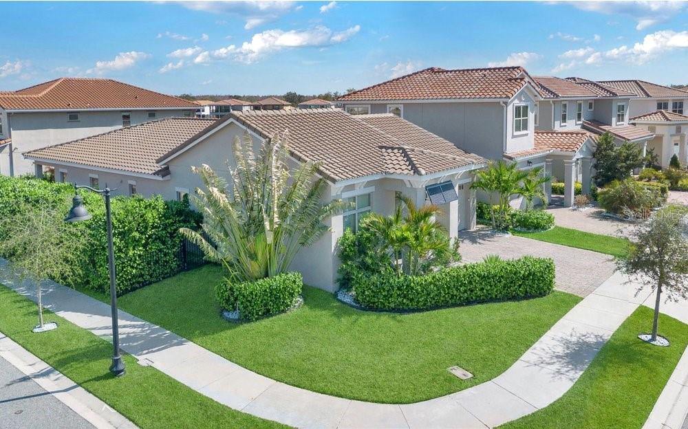 A two-story suburban house with a tiled roof, green lawn, and manicured hedges — 13321 OAKENSHAW LANE, ORLANDO, FL