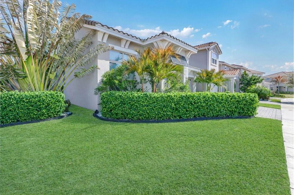 A two-story house with a manicured lawn, a trimmed hedge, and palm trees — 13321 OAKENSHAW LANE, ORLANDO, FL