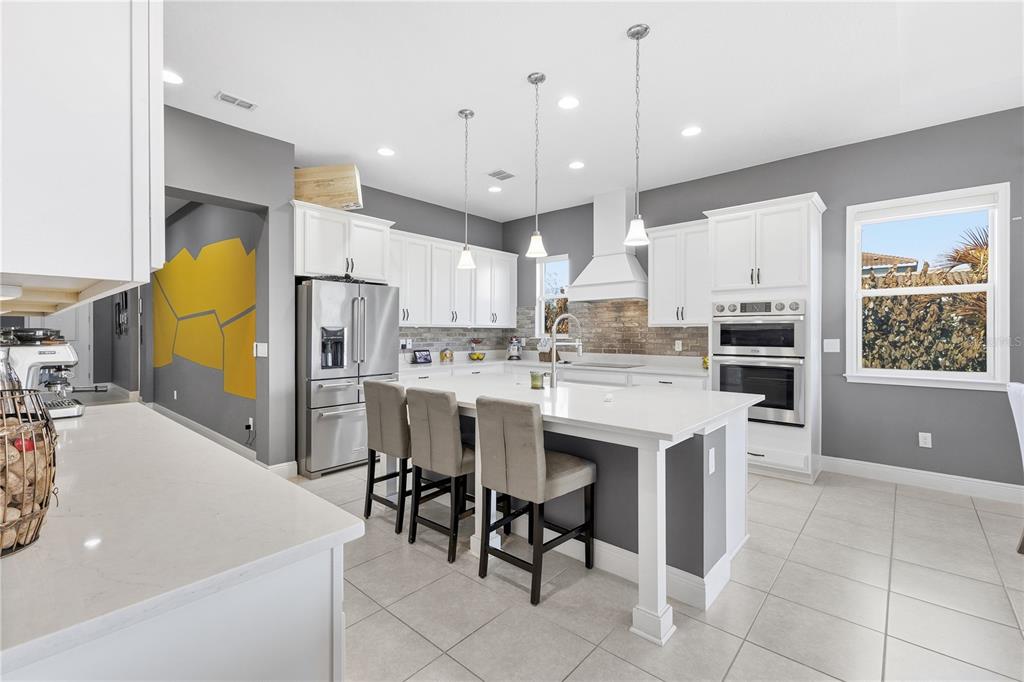 A bright, open-concept living and dining area features a large sectional sofa and neutral decor — 13321 OAKENSHAW LANE, ORLANDO, FL