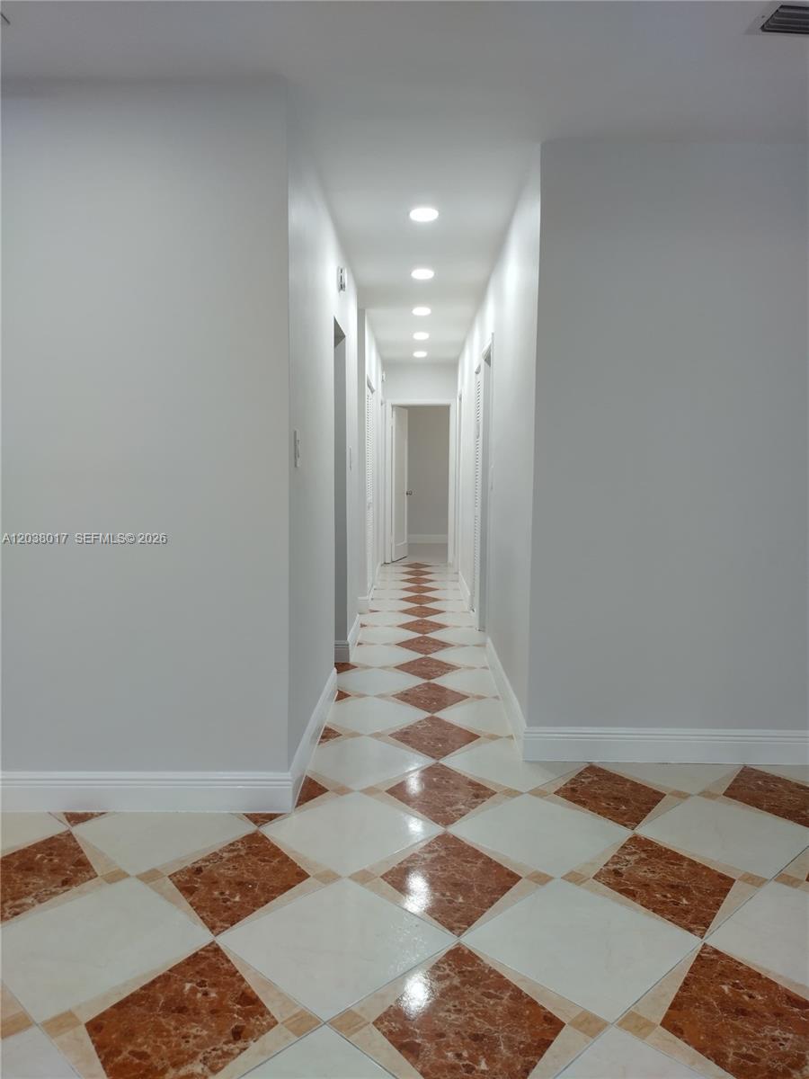 A hallway features light gray walls, recessed ceiling lights, and a diamond-patterned tile floor — 265 NW 190th St, Miami Gardens FL 33169, MIAMI GARDENS, FL