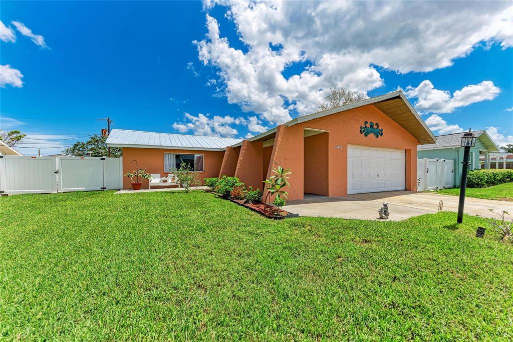A single-story orange house with a white garage door and a large front lawn — 2406 15TH STREET W, PALMETTO, FL