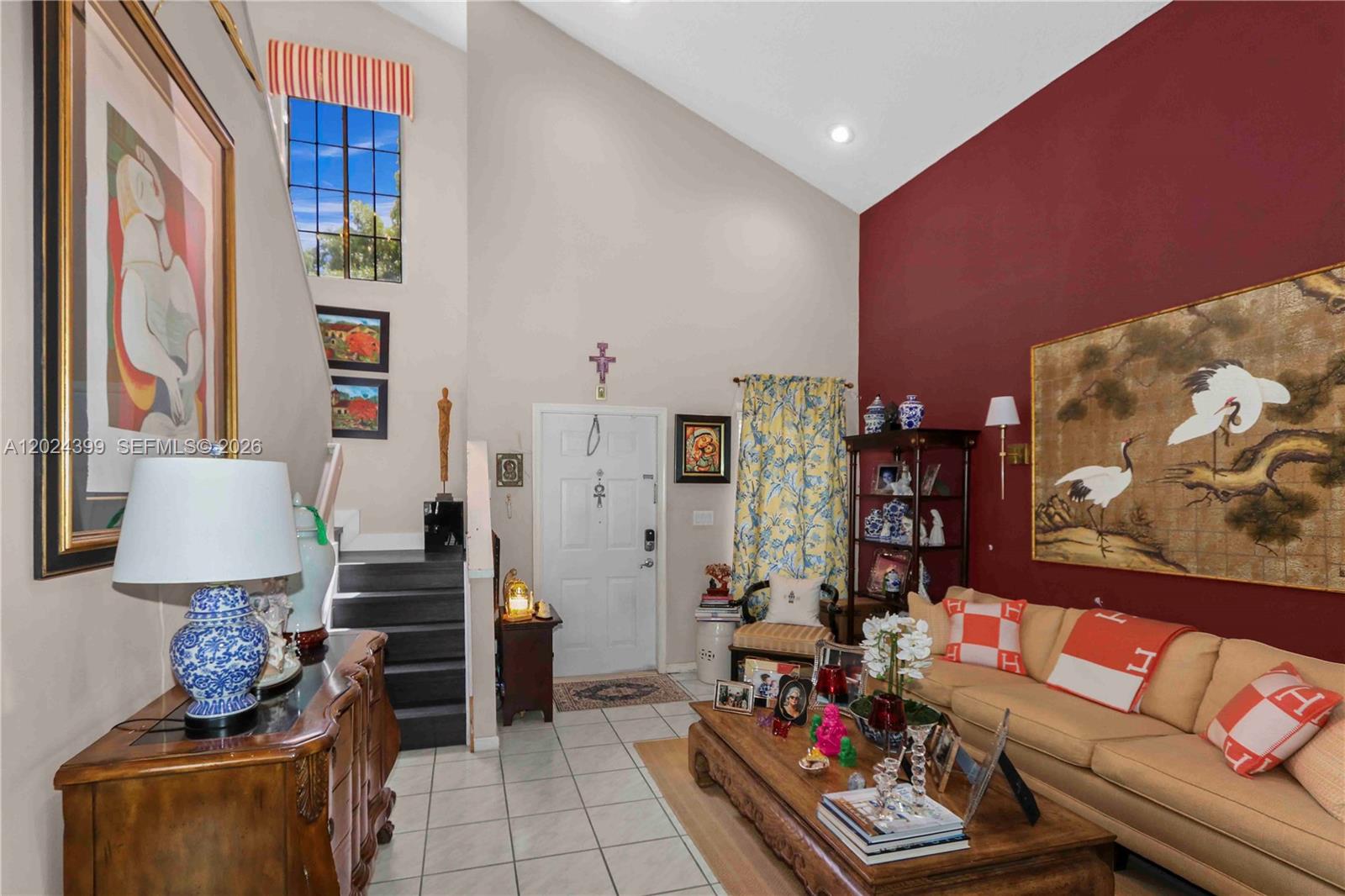 A living room features a high vaulted ceiling, a red accent wall, and tiled flooring — 14454 SW 138th Ct, Miami FL 33186, MIAMI, FL