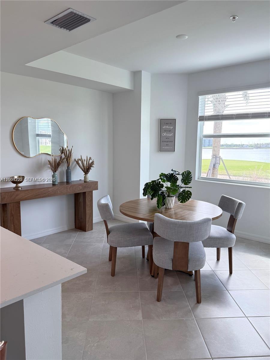 A dining area features a round wooden table, gray chairs, and a console table — 5555 Double Eager Circle # 3917, Ave Maria FL 34142, AVE MARIA, FL
