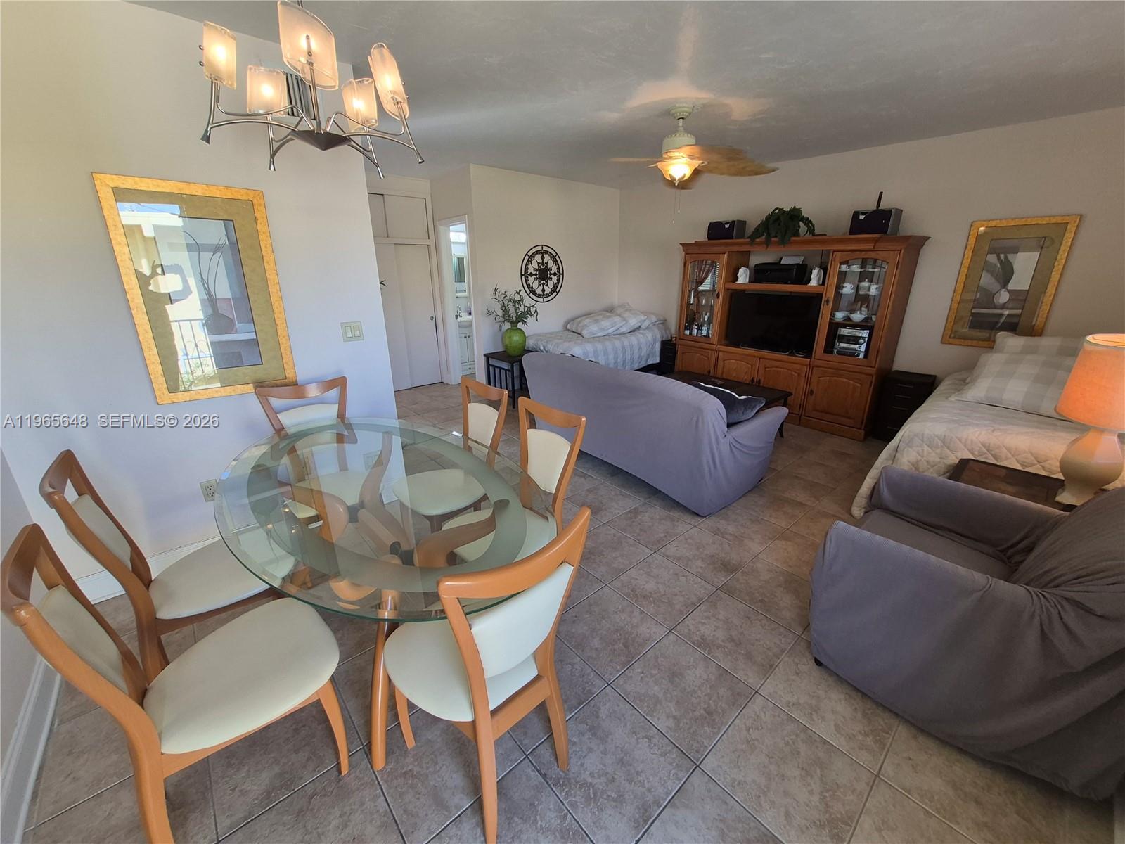 A dining area with a glass table sits in front of a living room space — 520 Euclid Ave # 8, Miami Beach FL 33139, MIAMI BEACH, FL